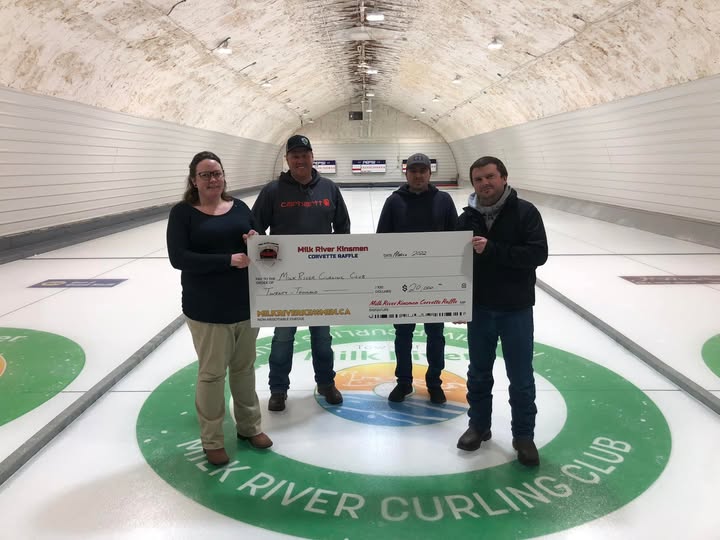Milk River Kinsmen volunteers present a novelty cheque from the Corvette Raffle at the Milk River Curling Club