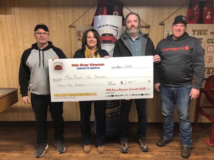Milk River Kinsmen volunteers present a novelty cheque from the Corvette Raffle to the Milk River Ag Society